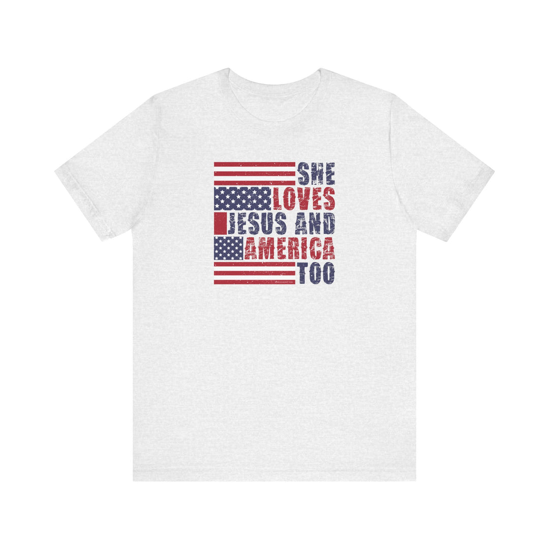 A She Loves Jesus and America Tee, a white shirt with red and blue text. Unisex jersey tee with ribbed knit collars, taping on shoulders, and tear away label. 100% Airlume combed cotton.