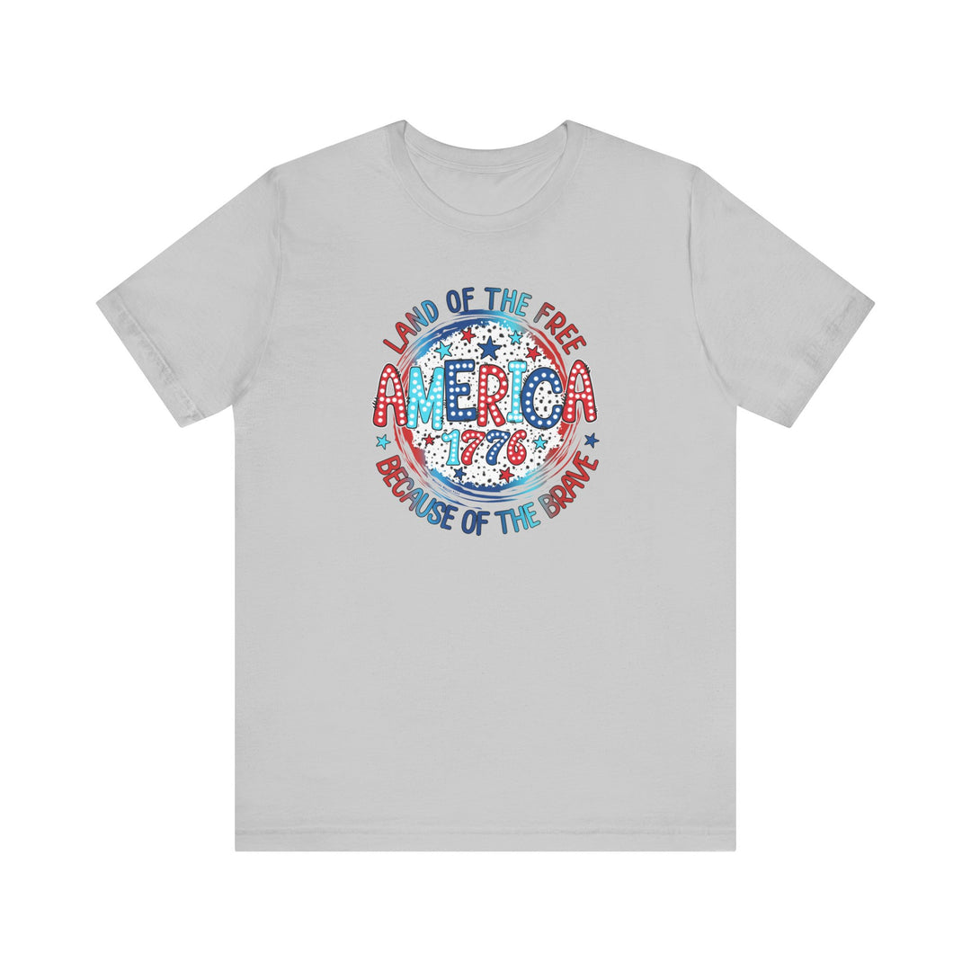 A classic unisex jersey tee featuring red, white, and blue America 1776 text. Made of 100% cotton, with ribbed knit collars, taping on shoulders, and tear-away label. Retail fit, light fabric.