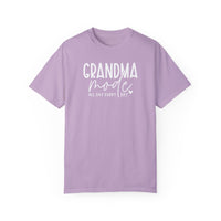 Grandma Mode Tee: A purple shirt with white text, made of 100% ring-spun cotton. Features a relaxed fit, double-needle stitching, and seamless design for durability and comfort. Ideal for daily wear.