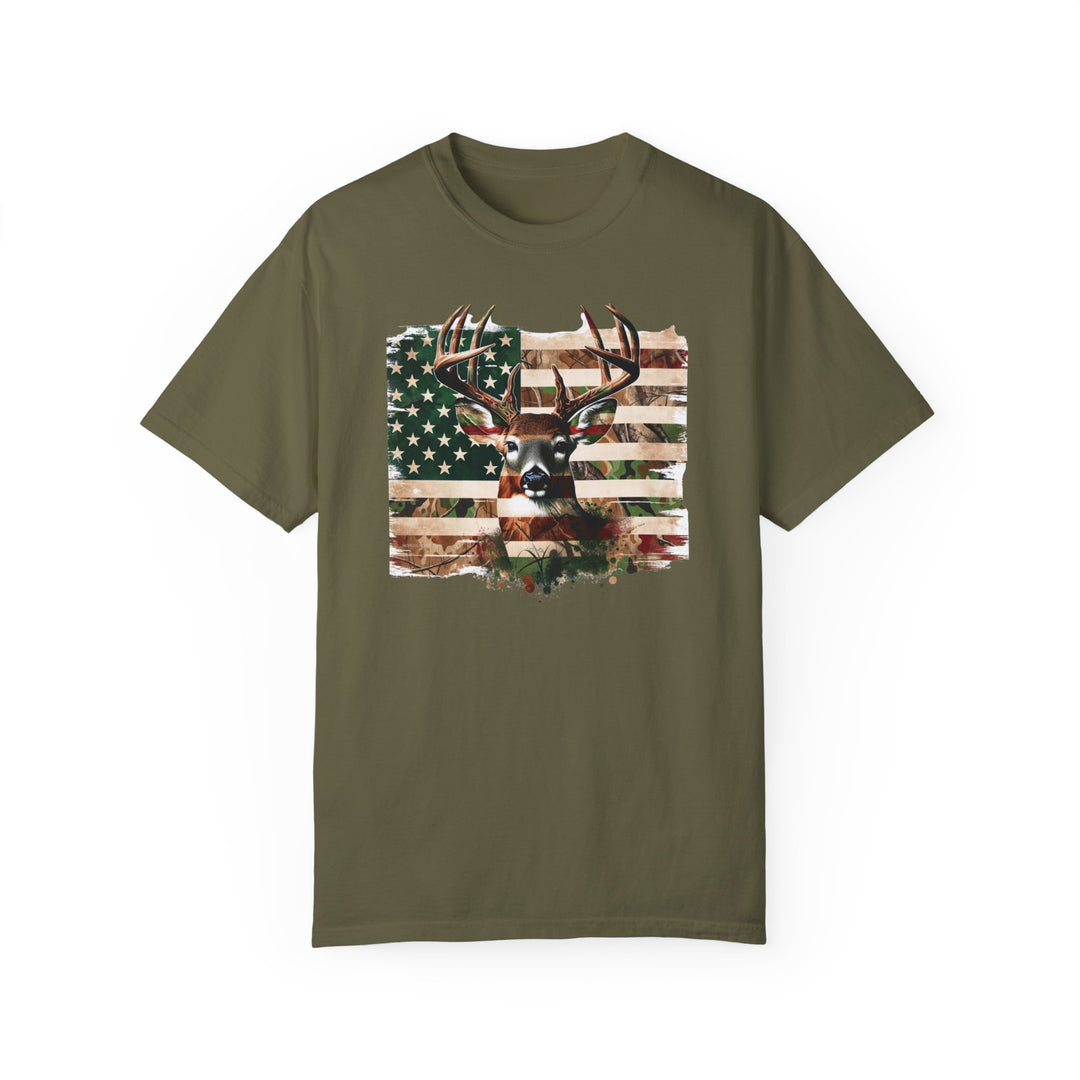 A relaxed fit Deer Flag Tee, featuring a deer head and flag design on a green shirt. 100% ring-spun cotton, garment-dyed for coziness, with double-needle stitching for durability. From Worlds Worst Tees.