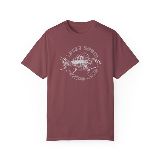 Lucky Bones Fishing Club Tee: Red shirt with fish skeleton graphic. 100% ring-spun cotton, garment-dyed for coziness. Relaxed fit, double-needle stitching for durability, seamless sides. Sizes: S-3XL.