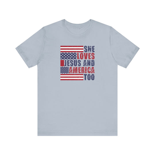 A classic She Loves Jesus and America Tee, featuring a flag design and text. Unisex jersey shirt with ribbed knit collar, 100% cotton, retail fit, tear away label. Sizes XS to 3XL.