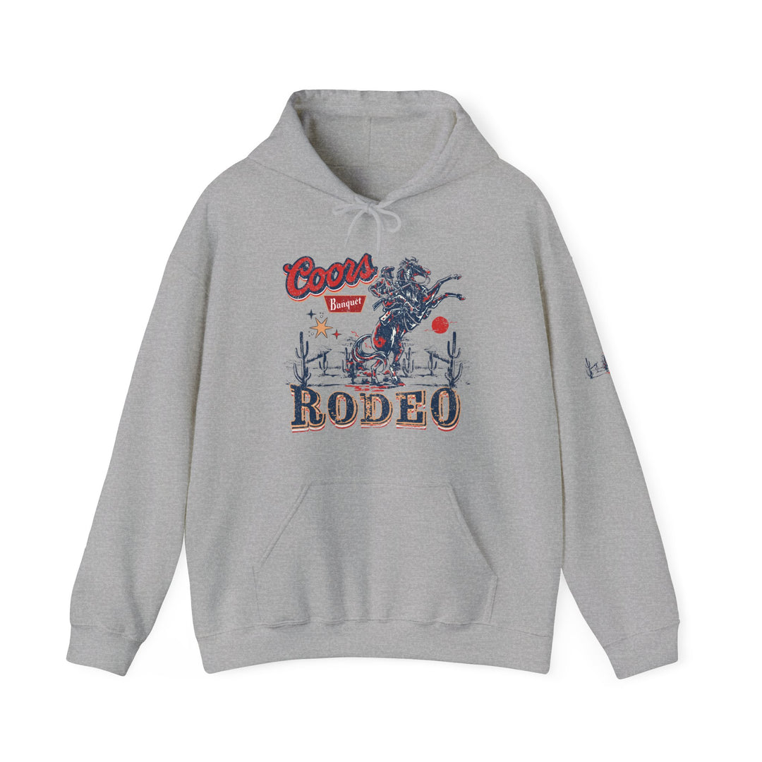 Coors Rodeo Hoodie: A grey sweatshirt featuring a cowboy graphic, ideal for relaxation. Thick cotton-polyester blend, kangaroo pocket, and drawstring hood. Unisex, classic fit, and tear-away label. Sizes S-5XL.