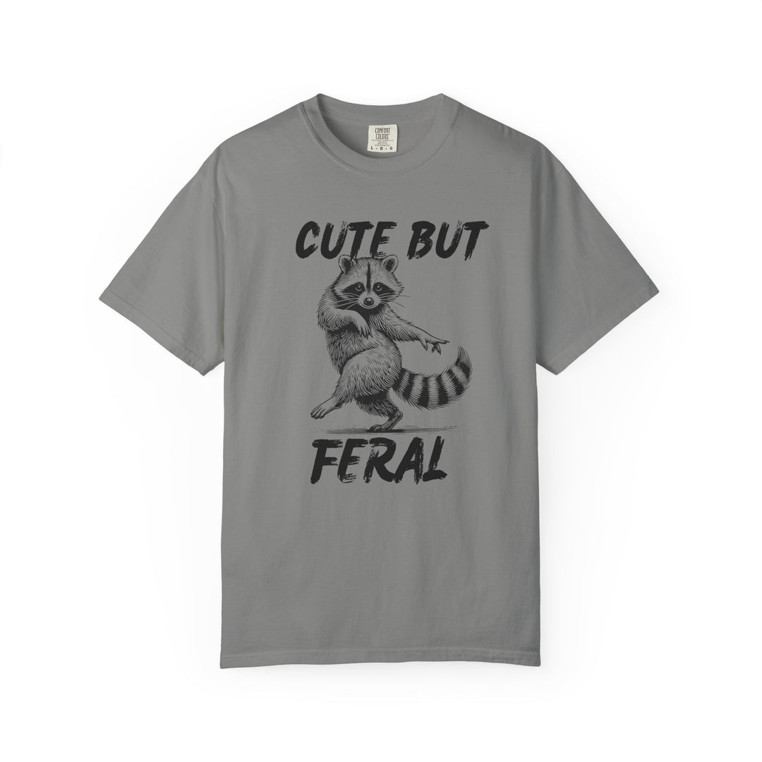 Cute but Feral Tee featuring a dancing raccoon illustration with bold text, made from soft, durable ring-spun cotton, offering comfort and a relaxed fit.