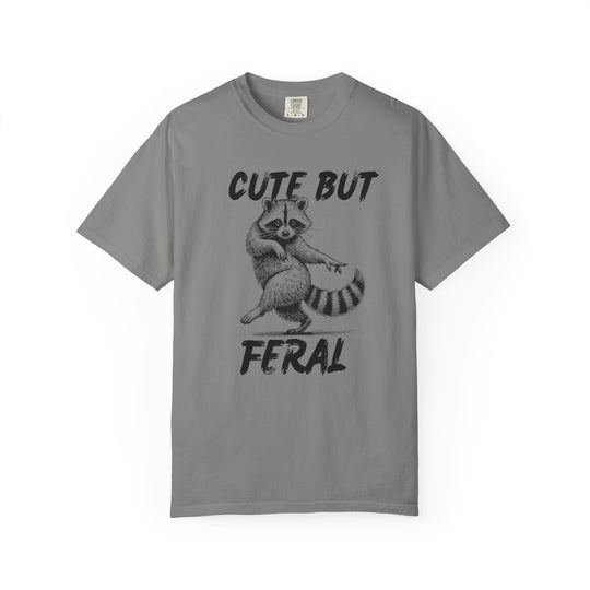 Cute but Feral Tee featuring a dancing raccoon illustration with bold text, made from soft, durable ring-spun cotton, offering comfort and a relaxed fit.