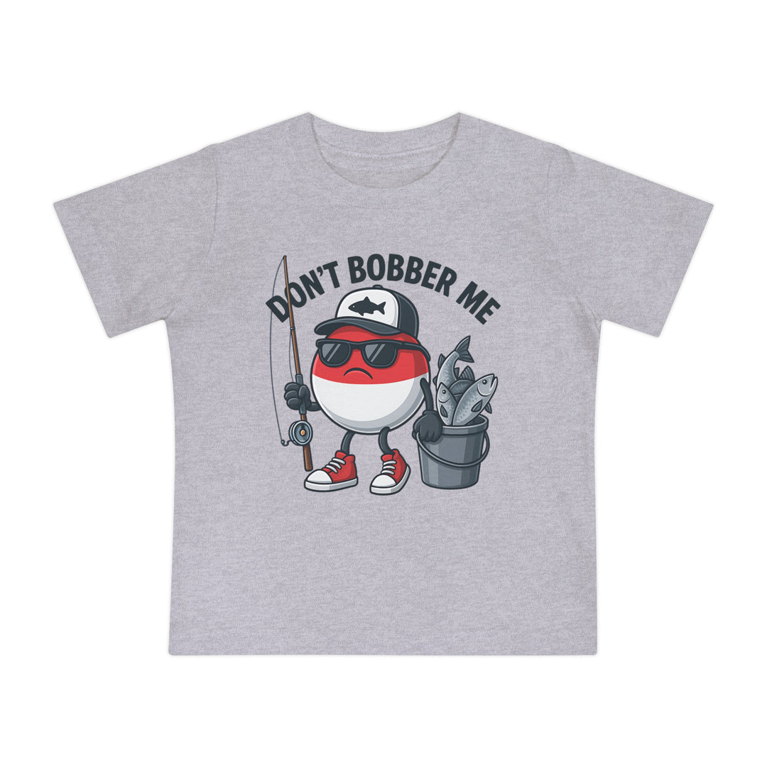 Light-gray baby tee with cartoon fishing bobber character, wearing a cap, sunglasses, and sneakers, holding a rod and bucket. Text reads DON’T BOBBER ME.