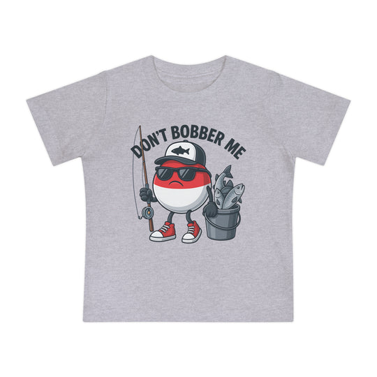 Light-gray baby tee with cartoon fishing bobber character, wearing a cap, sunglasses, and sneakers, holding a rod and bucket. Text reads DON’T BOBBER ME.