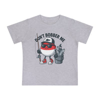 Don't Bobber Me Baby Tee featuring a cartoon fishing-bobber character with cap, sunglasses, rod, and fish bucket, paired with a playful slogan, on a soft, shrink-resistant fabric.