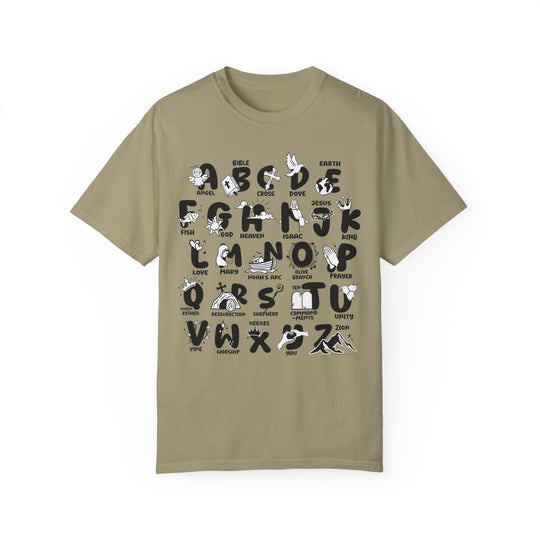 A Bible Alphabet Tee featuring a tan shirt with black and white graphic designs. Made of 100% ring-spun cotton, garment-dyed for extra coziness and durability. Relaxed fit with double-needle stitching for a daily staple.