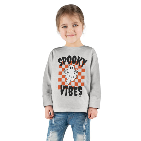 A spooky vibes toddler long sleeve tee featuring a ghost design on a white shirt. Made of 100% combed ringspun cotton, with topstitched ribbed collar and EasyTear™ label for comfort and durability.