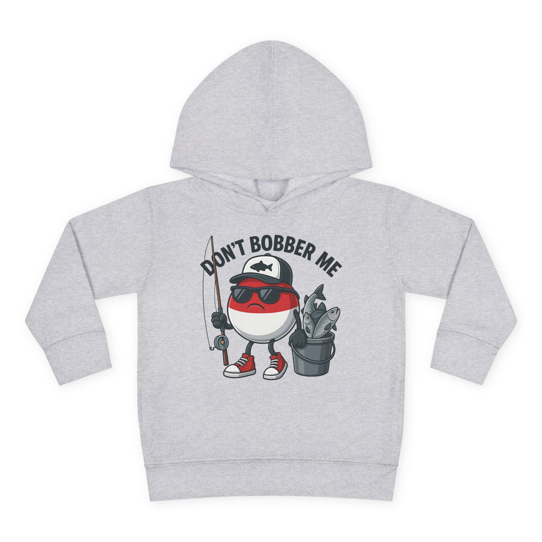Don't Bobber Me Toddler Hoodie features a cartoon fishing bobber with sunglasses and fishing gear, emphasizing playful design and comfort for kids.