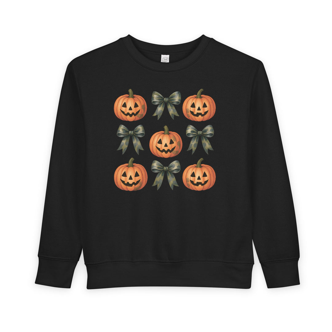 Pumpkins and Bows Toddler Crew: Black sweatshirt featuring a 3×3 grid of Halloween-themed jack-o’-lanterns and camouflage-pattern bows, designed for warmth and durability.