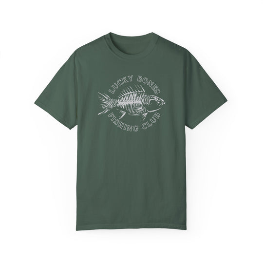 A Lucky Bones Fishing Club Tee, a green t-shirt with a fish skeleton graphic. 100% ring-spun cotton, garment-dyed for coziness, featuring a relaxed fit and durable double-needle stitching. Ideal for daily wear.