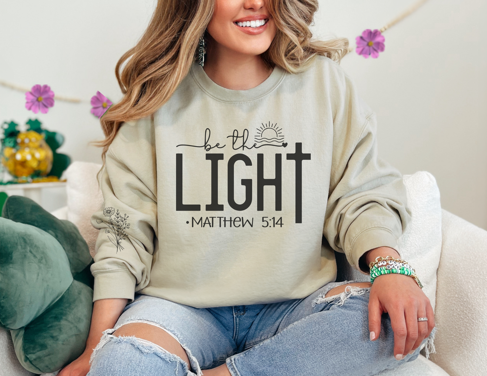A unisex heavy blend crewneck sweatshirt, the Be the Light Crew, offers comfort and durability. Made of 50% cotton and 50% polyester, featuring ribbed knit collar and double-needle stitching for a cozy fit.