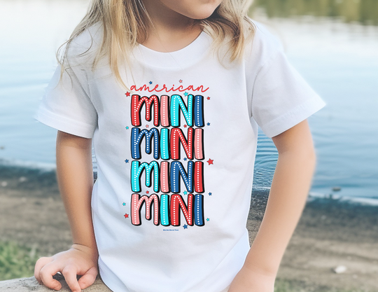 A toddler tee for first adventures, featuring a child near water. American Mini Toddler Tee in soft 100% ringspun cotton, light fabric, classic fit, and tear-away label. Sizes: 2T, 3T, 4T, 5-6T.