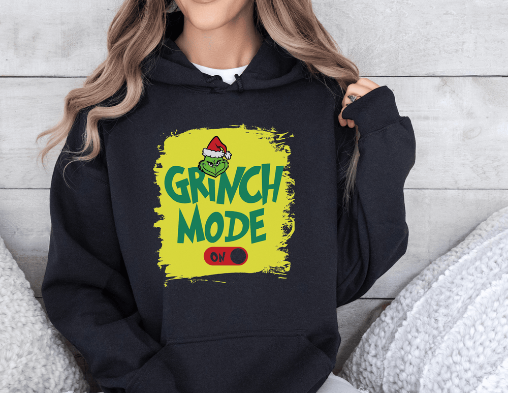 A Grinch Mode On Hoodie, a cozy unisex blend of cotton and polyester, featuring a kangaroo pocket and a matching drawstring hood. Perfect for warmth and comfort. Classic fit, tear-away label.
