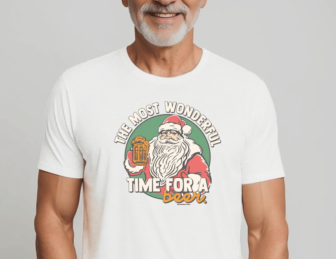 A man in a white shirt with a Santa Claus graphic design holding a beer, showcasing the Most Wonderful Time for a Beer Tee from Worlds Worst Tees. Made of 80% ring-spun cotton and 20% polyester, featuring a relaxed fit and rolled-forward shoulder.