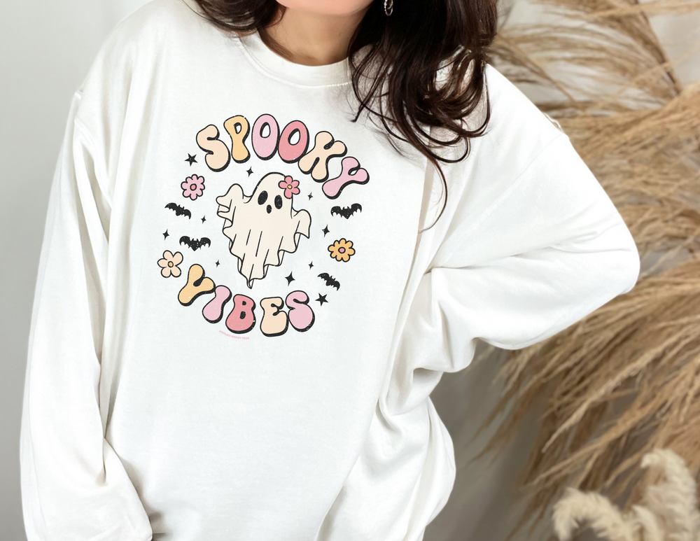 A cozy unisex crewneck sweatshirt featuring a cartoon ghost design with flowers and bats. Made of 50% cotton and 50% polyester, with ribbed knit collar for shape retention. From Worlds Worst Tees.