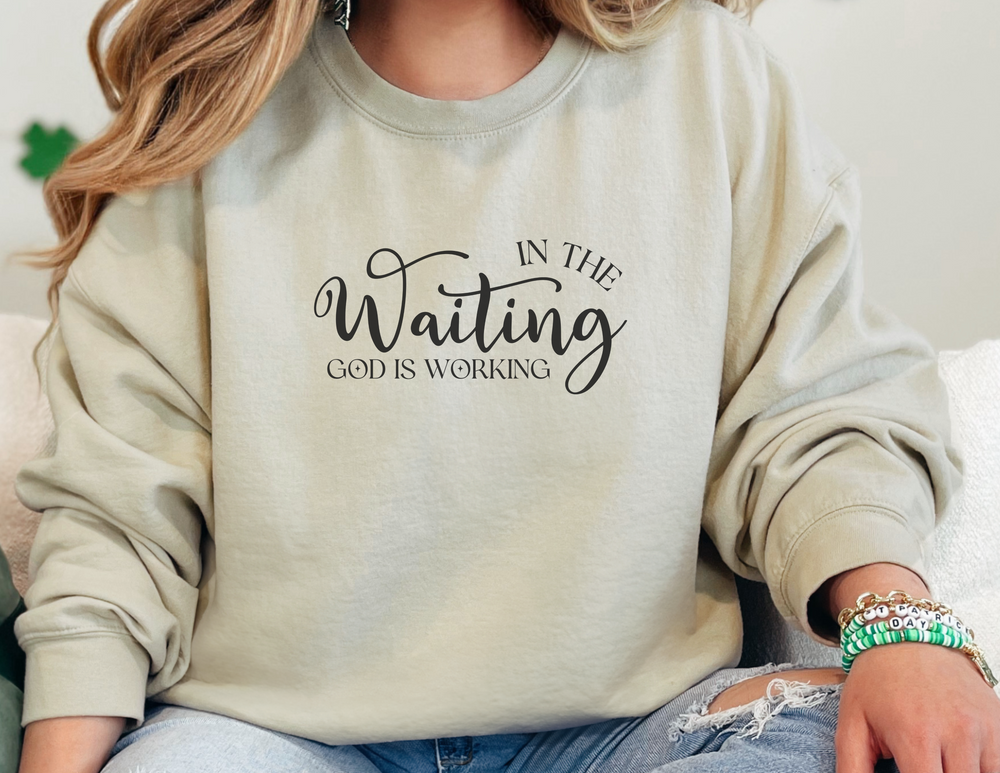 A woman in a God is Working Crew sweatshirt, showcasing comfort and style. Unisex heavy blend crewneck with ribbed knit collar, 50% cotton, 50% polyester, loose fit, and no itchy seams.