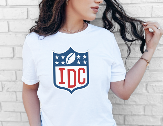 A classic NFL I Don't Care Tee in white, showcasing a woman in a white shirt. Unisex fit with ribbed knit collars, taping on shoulders, and 100% cotton fabric. Sizes XS to 3XL.