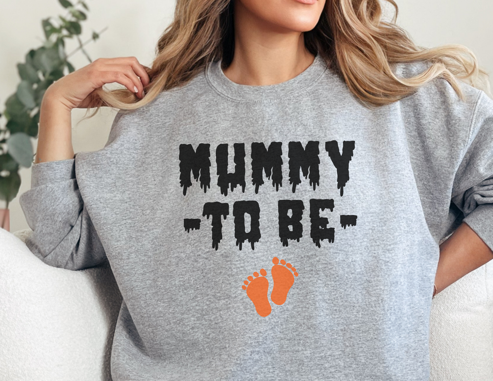 A unisex heavy blend crewneck sweatshirt, the Mummy To Be Crewneck, offers comfort with ribbed knit collar, no itchy side seams, and a loose fit. Made from 50% cotton and 50% polyester.