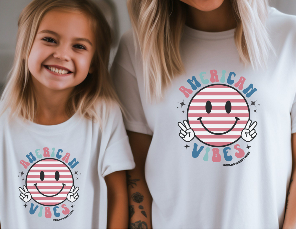A girl and a woman pose in American Vibes Youth Tee, a comfy 100% cotton shirt for active kids. Soft-washed, garment-dyed fabric in a classic fit for all-day wear.