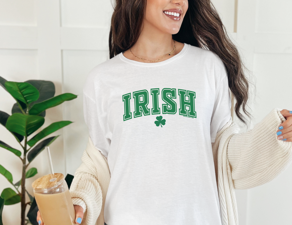 A woman in a white Irish Tee holding a drink, showcasing the classic fit and medium weight fabric. Unisex heavy cotton tee with no side seams for ultimate comfort and durability.