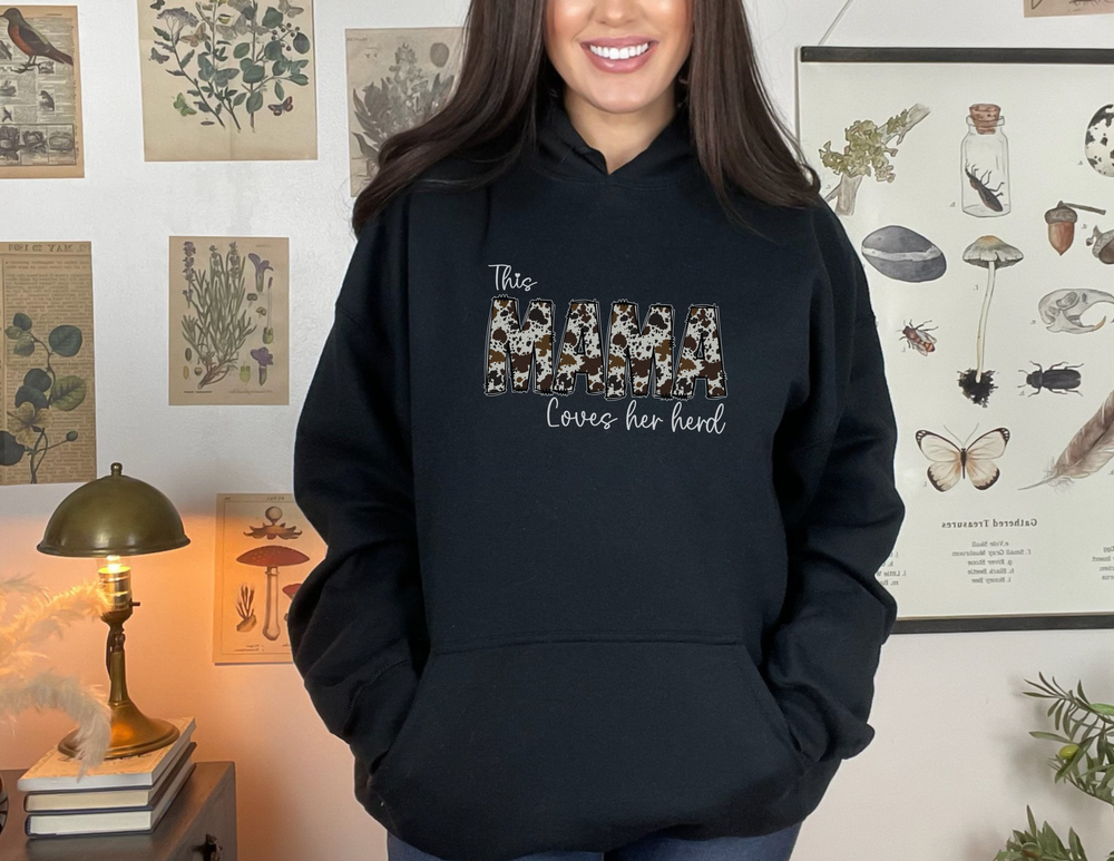 A unisex Mama Herd Hoodie, a blend of cotton and polyester, with a kangaroo pocket, no side seams, and a cozy hood with matching drawstring. Classic fit, tear-away label, medium-heavy fabric.