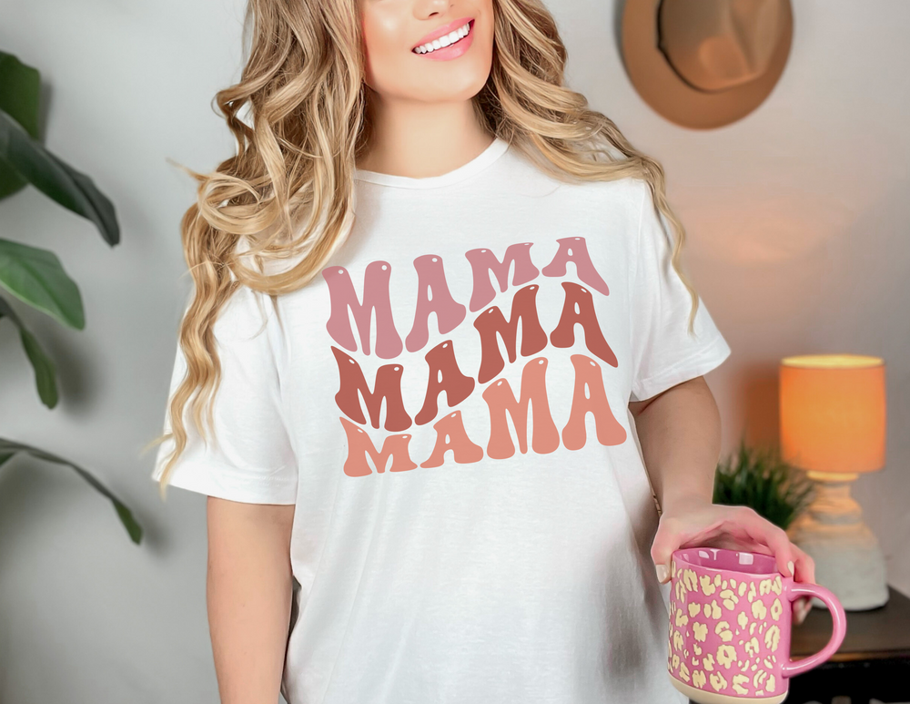 A woman smiling, holding a Mama Tee mug. Unisex heavy cotton tee with no side seams, ribbed knit collar, and durable tape on shoulders. Classic fit, 100% cotton. From Worlds Worst Tees.