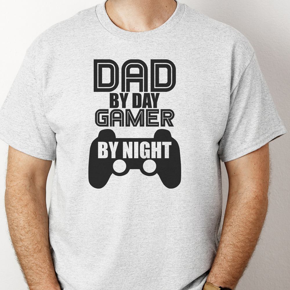 A fitted men’s tee, Dad by Day Gamer by Night, in premium cotton. Comfy, light, with elastic collar and roomy fit. Ideal for workouts or daily wear. Prioritize product title and key features.