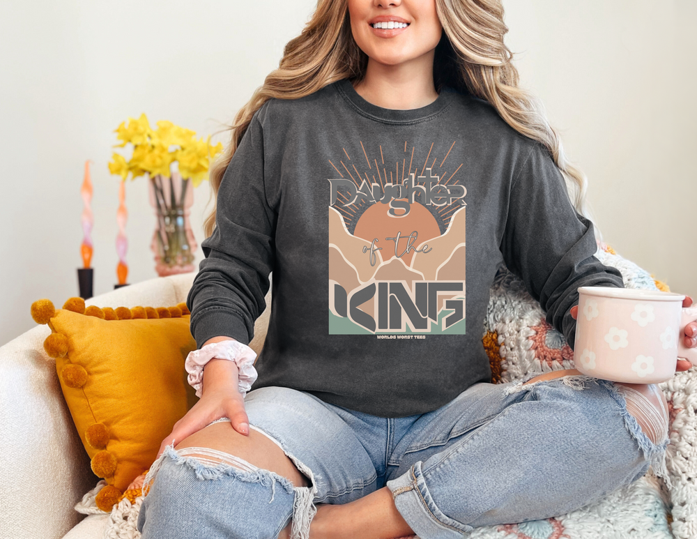 A woman in a cozy sweatshirt, embodying comfort and style. Unisex Daughter of the King Crew, 80% ring-spun cotton, 20% polyester, relaxed fit, rolled-forward shoulder, back neck patch.