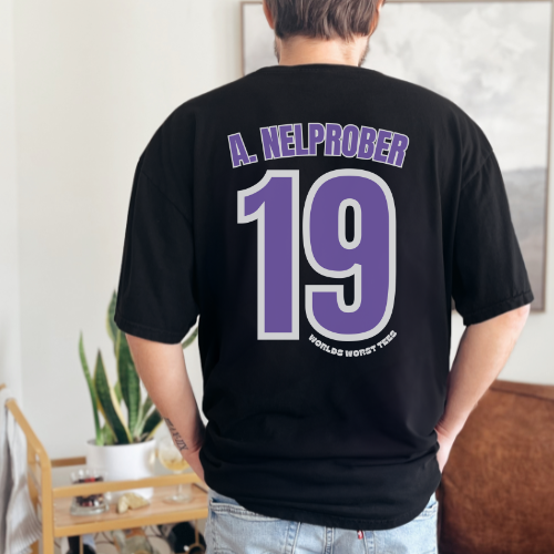 Alt text: Colorado Rockhards #19 A. Nelprober Tee: Men's black shirt with purple number, ribbed knit collar, roomy fit, 100% combed cotton, light fabric, premium fit, ideal for workouts and daily wear.