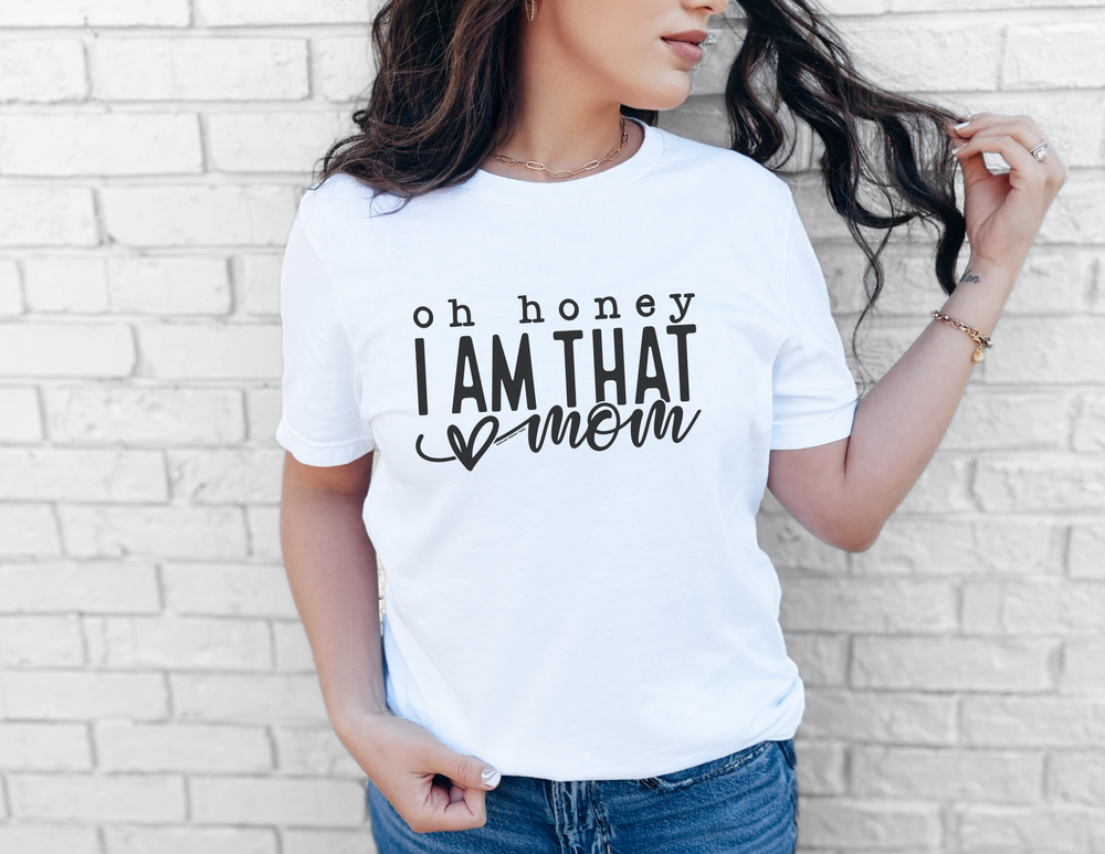 A relaxed fit Oh Honey I'm that Mom Tee in white, made of 100% ring-spun cotton. Garment-dyed for extra coziness, with double-needle stitching for durability and a seamless design for a tubular shape.