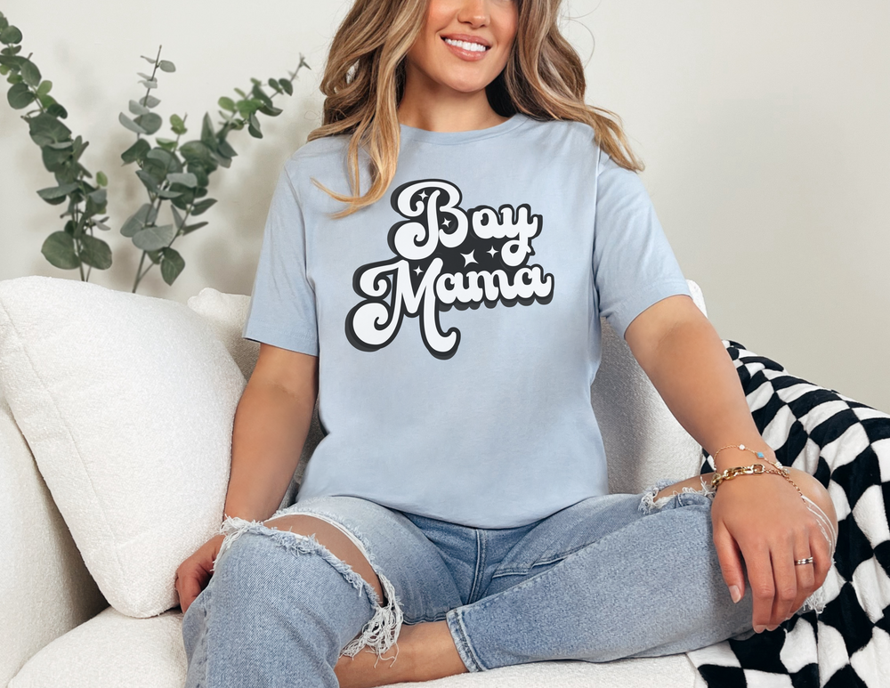 A relaxed fit Boy Mama Tee in ring-spun cotton, featuring a woman sitting on a couch. Garment-dyed for extra coziness, with double-needle stitching for durability and a tubular shape.