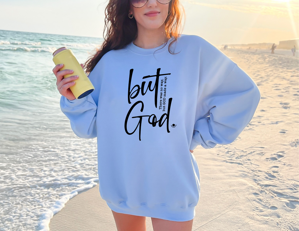 A unisex heavy blend crewneck sweatshirt, the 'But God Crew,' offers pure comfort with a ribbed knit collar and durable double-needle stitching. Made from 50% cotton and 50% polyester.