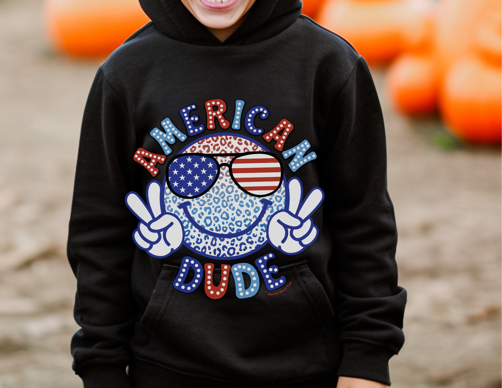 American Dude Toddler Hoodie featuring a cartoon face and sunglasses design. Jersey-lined hood, cover-stitched details, and side seam pockets for durability and coziness. 60% cotton, 40% polyester blend. Sizes: 2T, 4T, 5-6T.