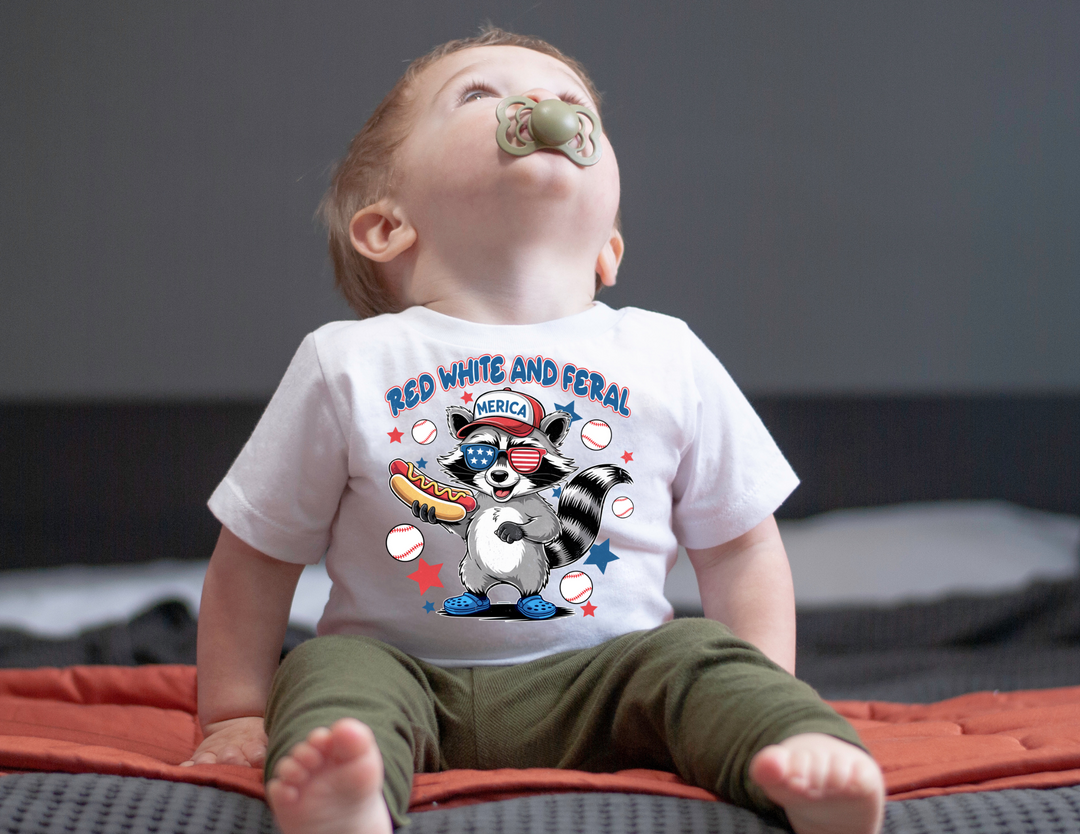 Infant fine jersey tee with Red White and Feral graphic, featuring ribbed knitting, taped shoulders, and side seams for durability and comfort; available in multiple sizes.
