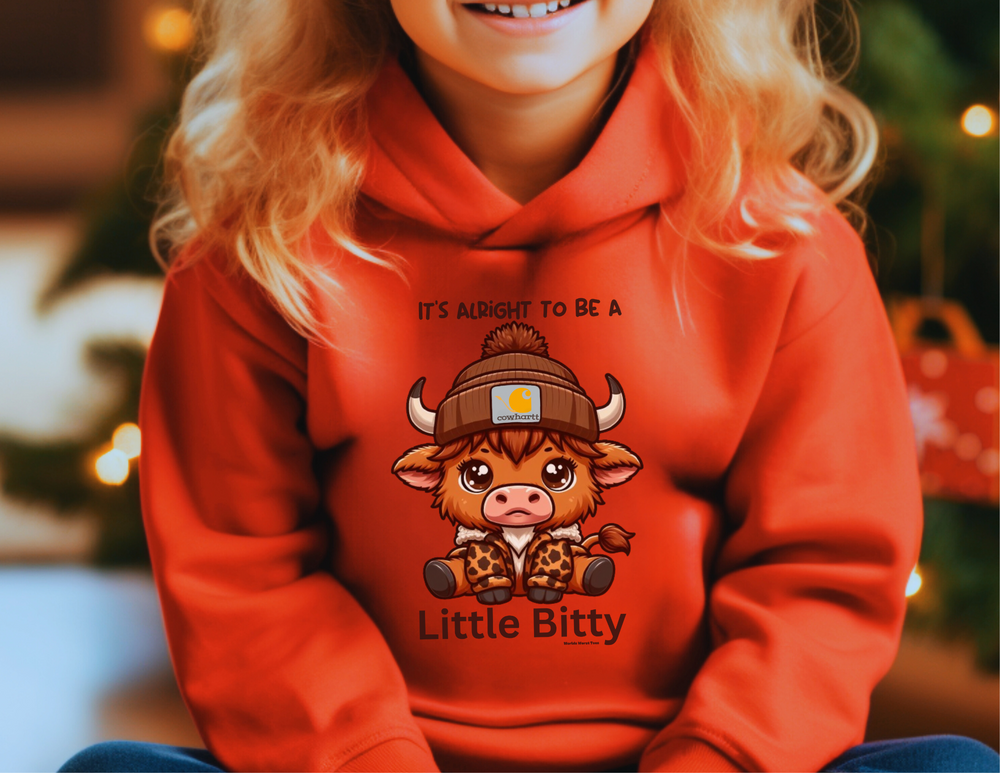 Little Bitty Toddler Hoodie: A girl smiling, wearing a comfy hoodie with side seam pockets. Jersey-lined hood, cover-stitched details for durability. Perfect for cozy days.