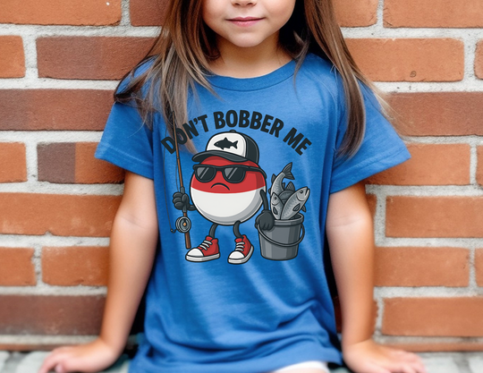 Toddler wearing Don't Bobber Me tee featuring a cartoon bobber character with a fishing rod and fish bucket, perfect for playful, everyday wear.