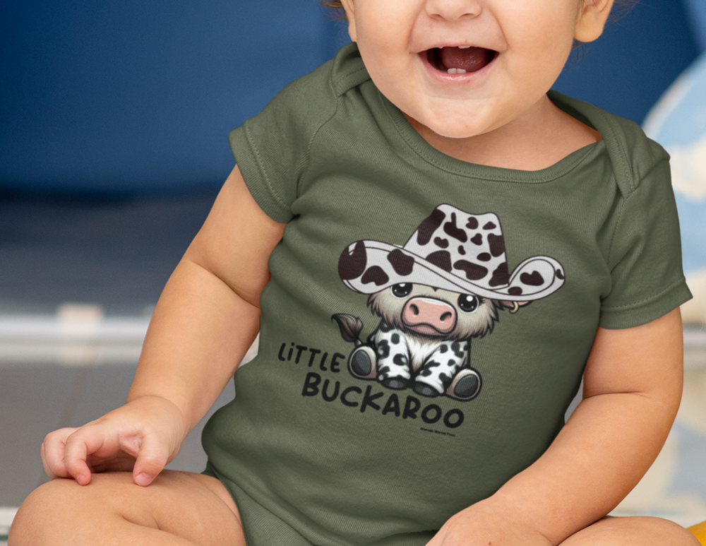 A baby smiling in a Buckaroo Onesie with a cartoon cow wearing a cowboy hat. Infant fine jersey bodysuit, 100% cotton, ribbed knit bindings, plastic snaps for easy changing. From Worlds Worst Tees.