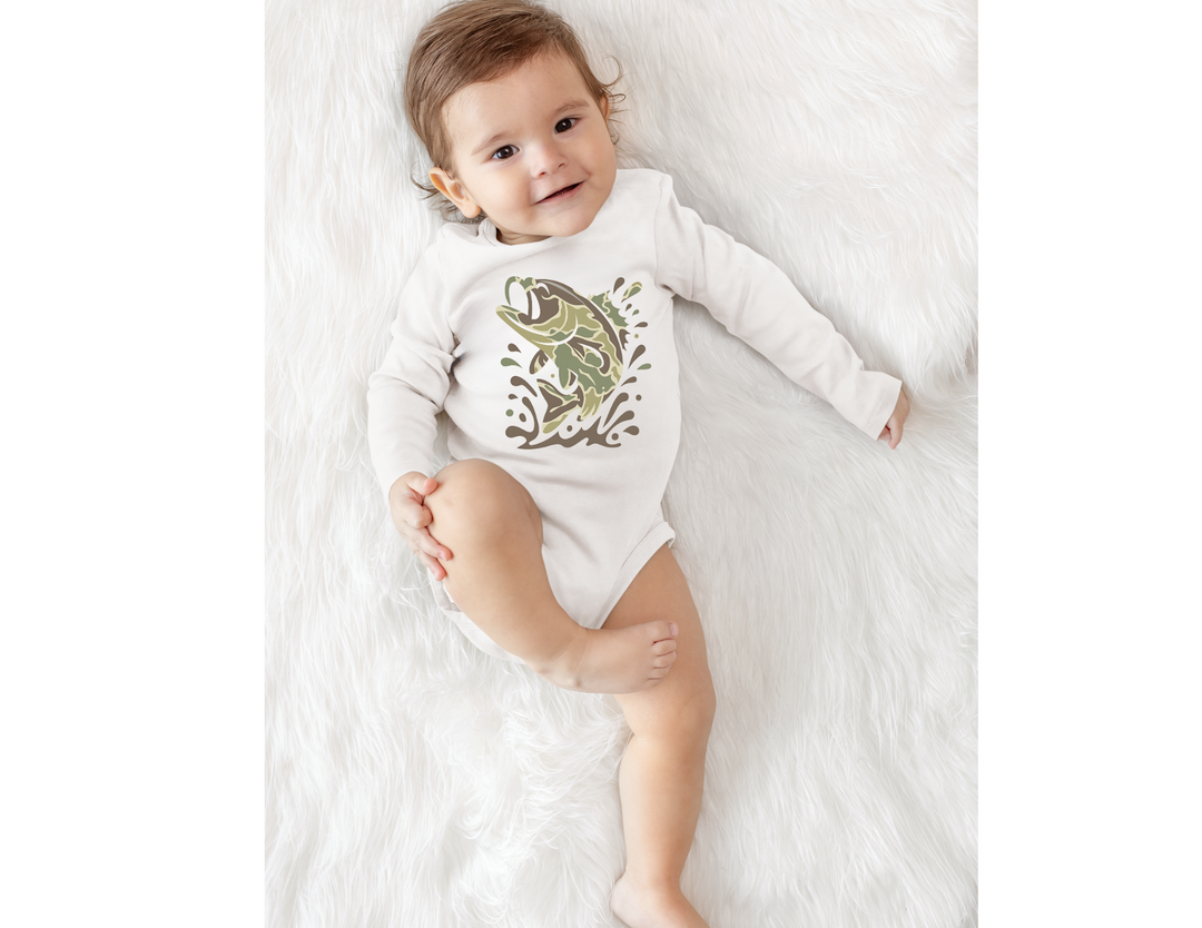 Baby wearing Camo Fish Long Sleeve Onesie on faux-fur surface, featuring a leaping bass graphic, designed for comfort and durability with ribbed bindings and snap closure.