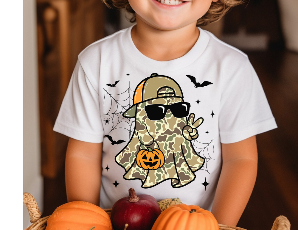 Child wearing the Candy Ghost Kids Tee featuring a camo-patterned ghost with a cap, sunglasses, and Halloween elements, ideal for everyday wear.