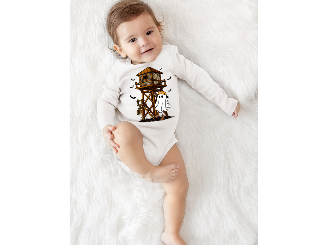 Baby wearing Ghost Hunter Long Sleeve Onesie with Halloween treehouse, ghost, bats on soft white surface, showcasing durable, soft cotton fabric with easy-change snaps.