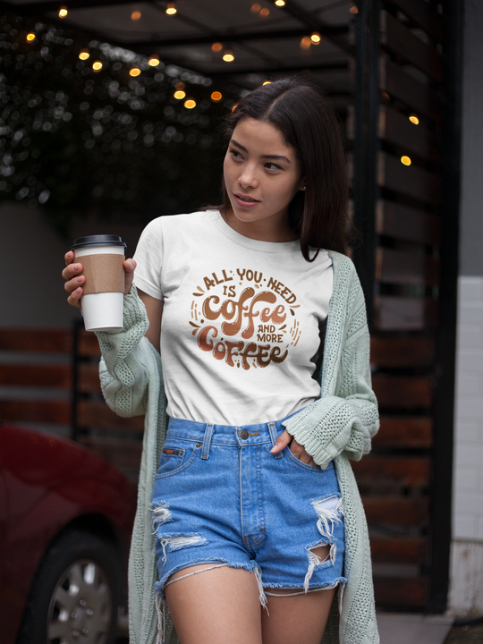 A woman in a white shirt holds a coffee cup, embodying casual style. Unisex All You Need is Coffee Tee, a wardrobe staple with ribbed knit collar and durable tape on shoulders. Classic fit, 100% cotton.