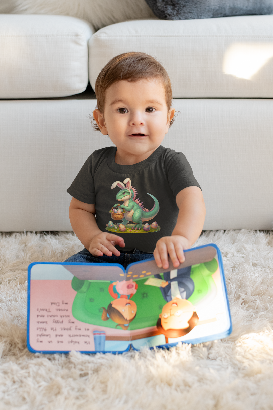 A baby in an Eggosaurus Onesie sitting with a book. Infant fine jersey bodysuit, 100% cotton, ribbed knitting for durability, plastic snaps for easy changes. From Worlds Worst Tees.