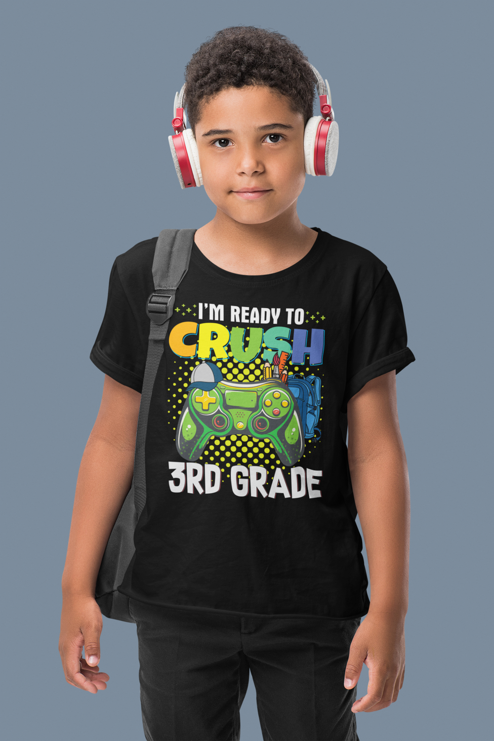 A boy in a black tee with a video game controller and backpack, wearing headphones. I'm Ready to Crush 3rd Grade Kids Tee by Worlds Worst Tees. Features 100% cotton, tear-away label, classic fit.