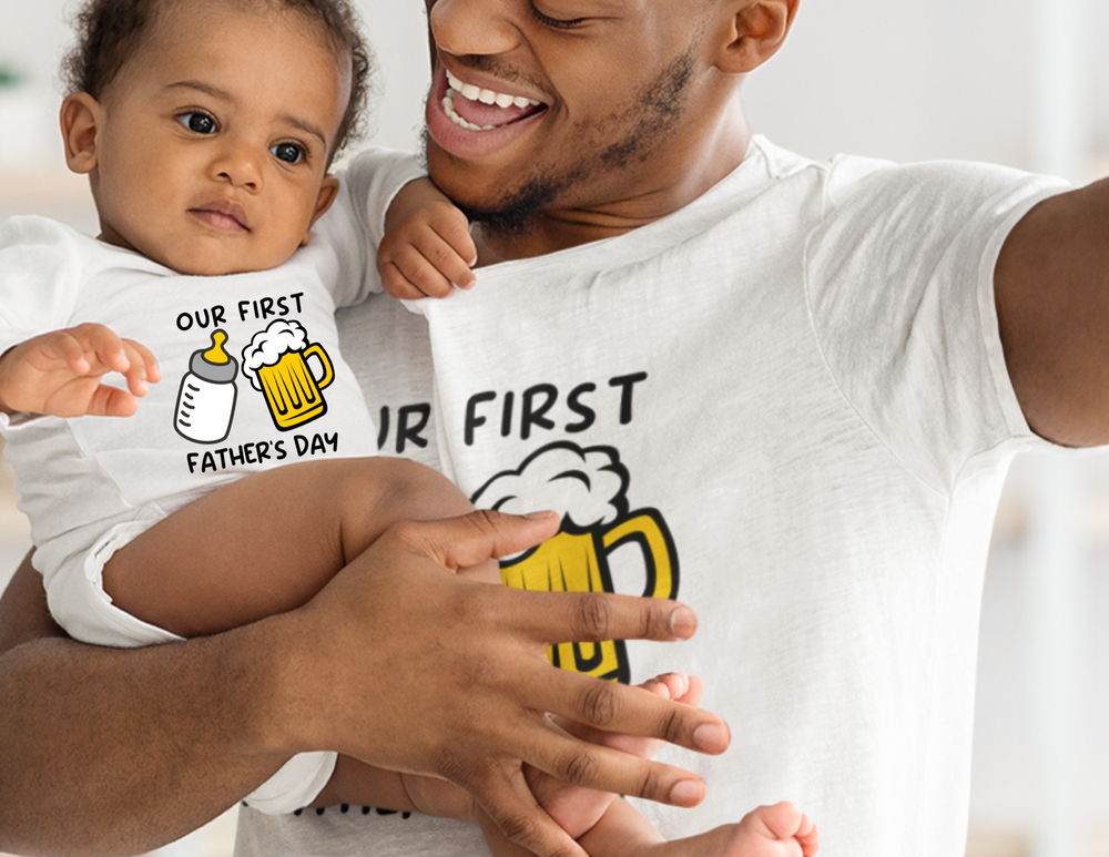 A man joyfully holds a baby in a soft, durable Our First Father's Day Onesie. Infant fine jersey bodysuit with ribbed knitting, plastic snaps for easy changing. Perfect for celebrating fatherhood.