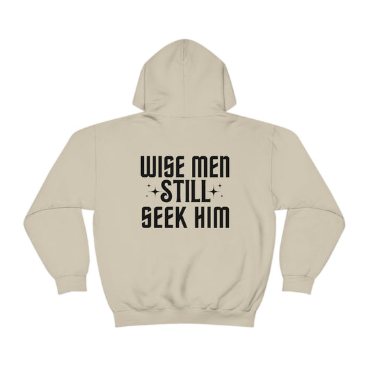 A white hoodie with black text, featuring Wise Men Still Seek Him. Unisex heavy blend of cotton and polyester, plush and warm, with kangaroo pocket and drawstring hood. From Worlds Worst Tees.