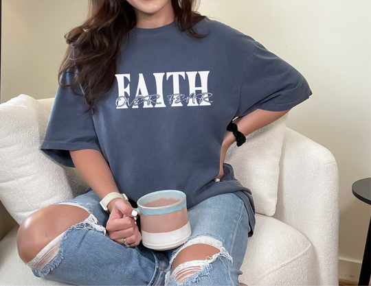 A relaxed fit Faith Over Fear Tee, crafted from 100% ring-spun cotton. Garment-dyed for coziness, with double-needle stitching for durability and a seamless design for a tubular shape.