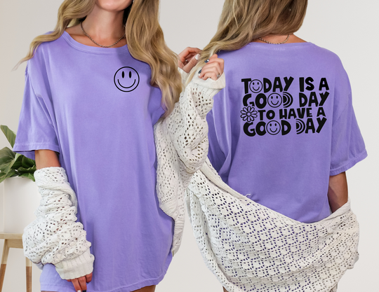 A relaxed-fit God Day to Have a Good Day Tee in purple, featuring a woman wearing it. Made of 100% ring-spun cotton for durability and comfort. Ideal for daily wear.